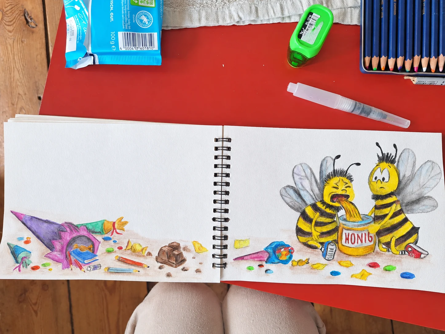Kristins aufgeklapptes Skizzenbuch mit zwei Bienen am Honigglas für ein Einschulungsetikett